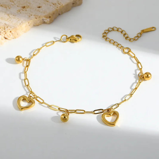 L04 - Pulsera cadena con dijes. Color dorado. Acero inoxidable.