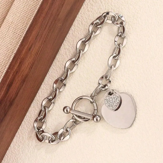 N20 - Pulsera con dijes de corazones con circonias. Color plateado. Acero inoxidable.