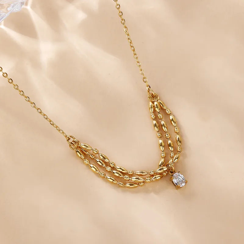 P19 - Collar con dije triple con circonia. Color dorado. Acero inoxidable.