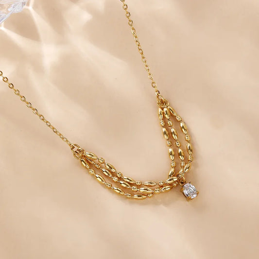 P19 - Collar con dije triple con circonia. Color dorado. Acero inoxidable.