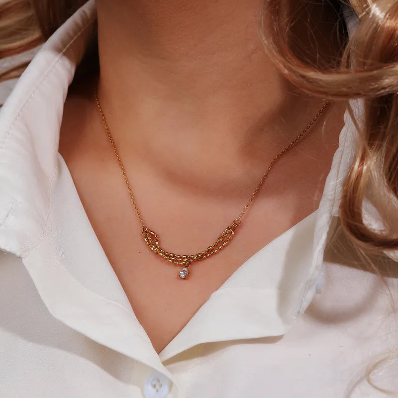 P19 - Collar con dije triple con circonia. Color dorado. Acero inoxidable.