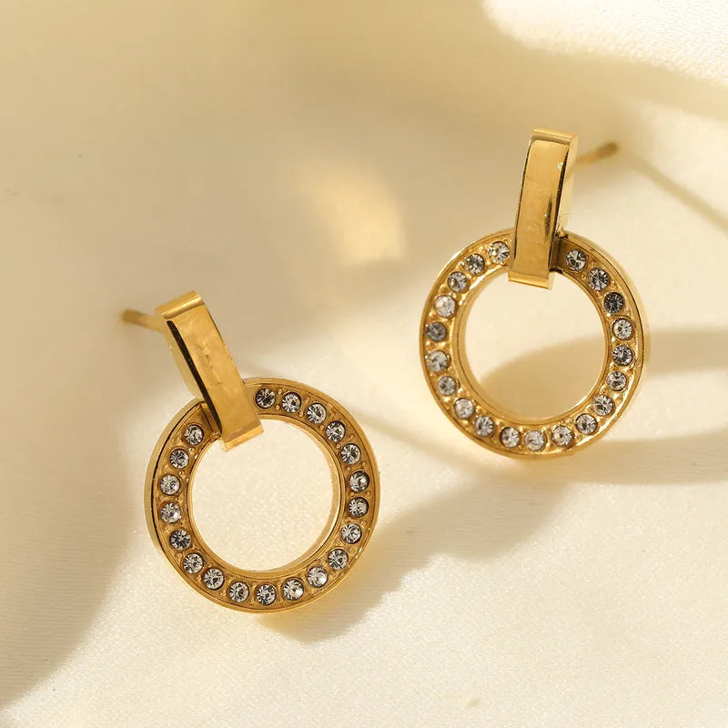 P23 - Aretes circulos con circonias. Color dorado. Acero inoxidable.